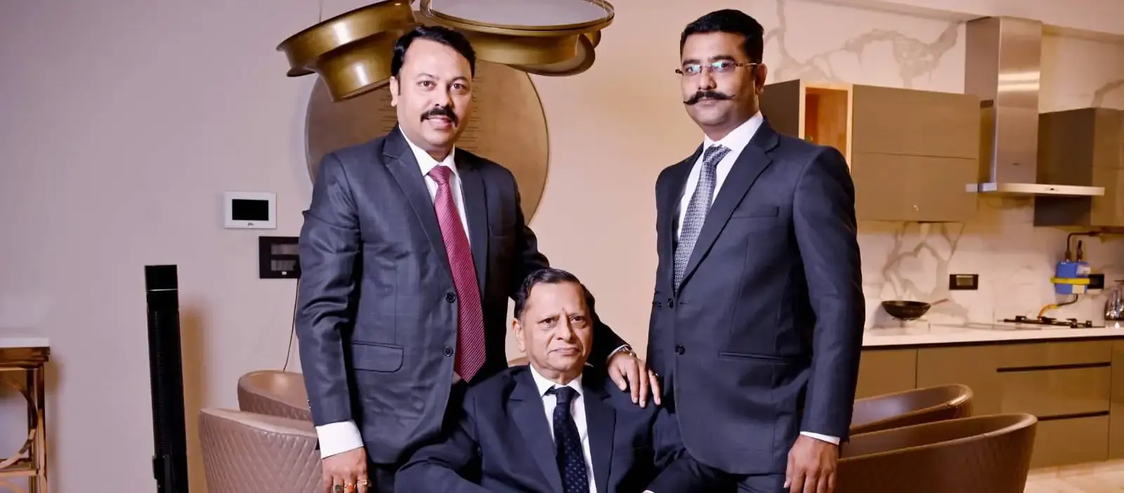 Ashok Gupta seated in the centre, with Mannish Gupta to the left and Ashish Gupta to the right